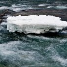A stone with ice in the river.