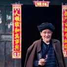 An old man in front of the door.